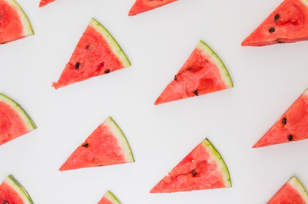 Tranches triangulaires de melon d&#39;eau isolés sur fond blanc