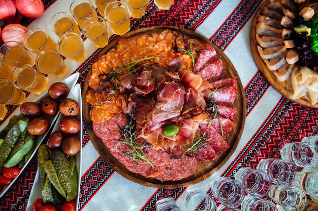 Des tranches de viande fumée servies avec de la verdure reposent sur le bois