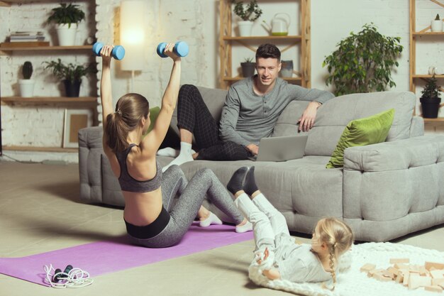 Travaille ses mains. Jeune femme faisant de l'exercice physique, aérobie, yoga à la maison, mode de vie sportif et salle de gym à domicile.