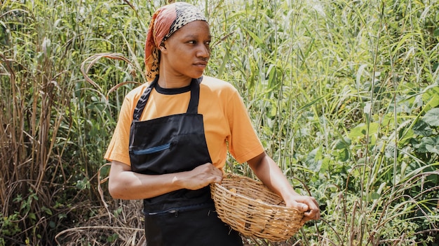 Photo gratuite travailleur de la campagne tenant un panier avec des arachides