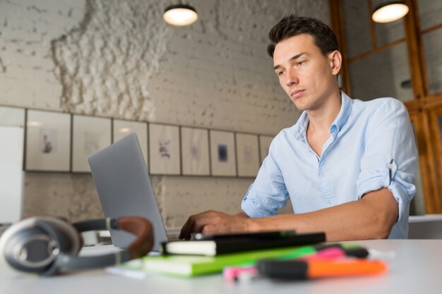 Travailleur à distance en ligne occupé jeune homme confiant travaillant sur ordinateur portable