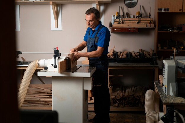 Photo gratuite travailleur du bois dans son atelier travaillant avec des outils et des équipements