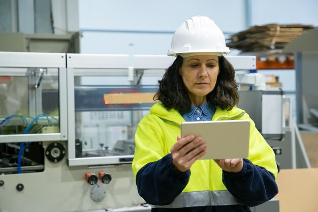 Travailleur industriel à l'aide d'une tablette sur place