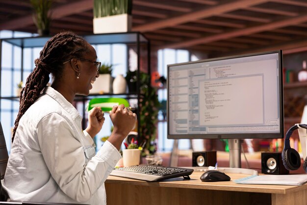 Un travailleur informatique joyeux satisfait après avoir testé le code et avoir vu de bons résultats
