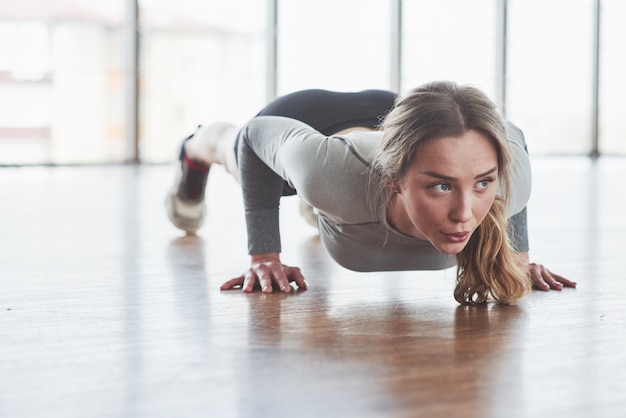 Travailleur. Jeune femme sportive ont une journée de remise en forme dans la salle de sport au matin