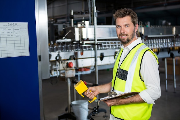 Travailleur masculin à l'aide de machines à l'usine de jus