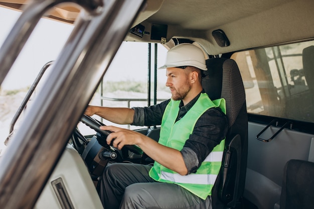 Travailleur masculin avec bulldozer dans la carrière de sable