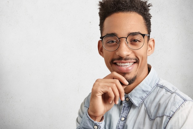 Un travailleur masculin positif ou une personne créative qui réussit porte des vêtements élégants, a une apparence spécifique