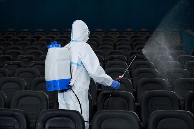 Travailleur nettoyant la salle de cinéma avec un équipement spécial