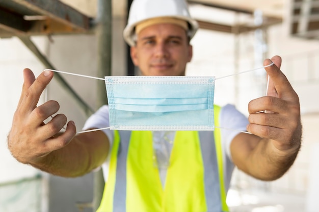 Photo gratuite travailleur portant un masque médical sur un chantier de construction