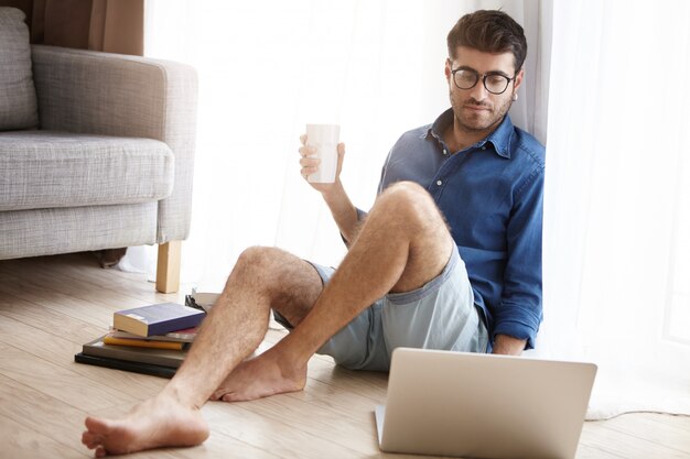 Travailleur scientifique masculin travaillant dur prépare un rapport sur un ordinateur portable