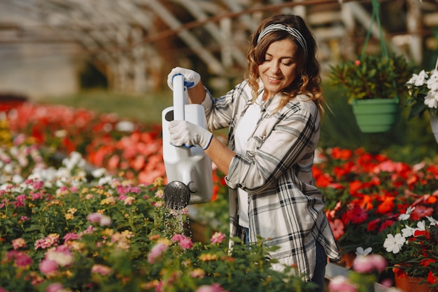 Le travailleur verse des pots de fleurs. Fille dans une chemise blanche. Femme avec entonnoir