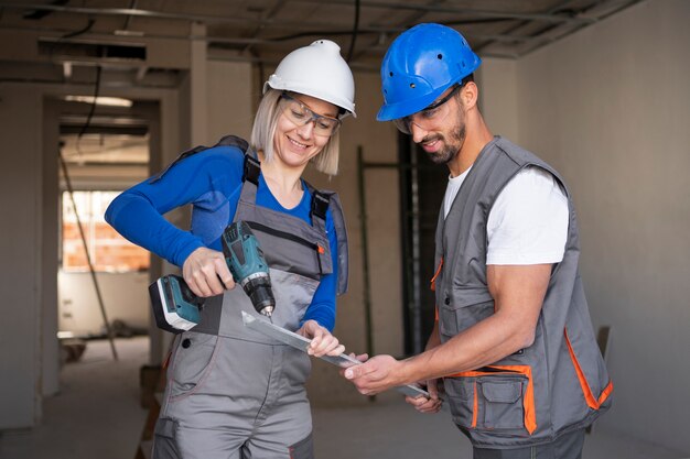 Travailleurs de la construction à coup moyen avec perceuse