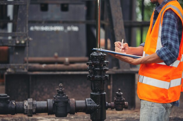 debouchage gembloux les travailleurs debout et vérifiant à côté des pompes à huile de travail.