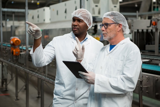 Travailleurs masculins travaillant dans une usine de boissons froides