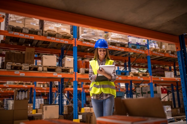 Photo gratuite travailleuse d'entrepôt vérifiant l'inventaire dans l'entrepôt de distribution