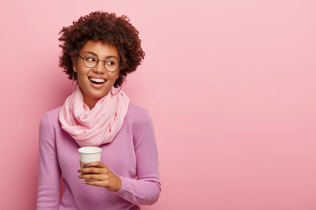 Une travailleuse frisée détendue positive bénéficie d'une pause-café, a parlé avec un collègue