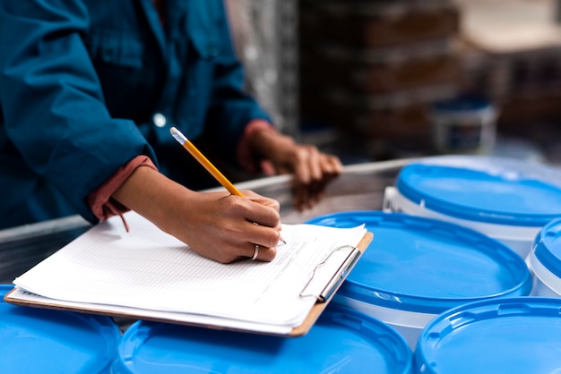 Photo gratuite travailleuse prenant des notes dans un entrepôt