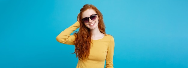 Travel concept close up portrait young beautiful attractive ginger red hair girl with trendy sunglas