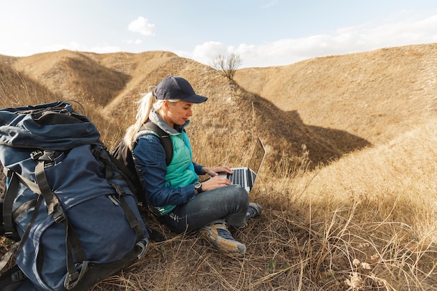 Traveller avec sac à dos et ordinateur portable en plein air