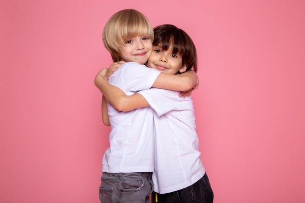 Étreindre amis petit enfant garçons mignon adorable sur mur rose