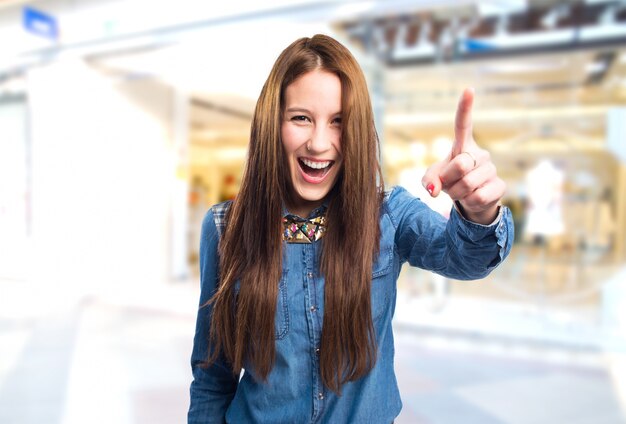 Trendy jeune femme pointant avec son doigt