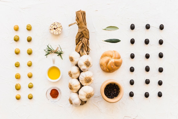 Photo gratuite tresse d'ail avec olives, chignon et ingrédients