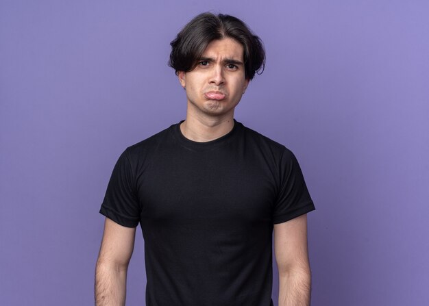 Triste jeune beau mec portant un t-shirt noir isolé sur un mur violet