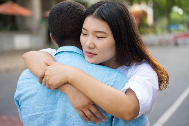 Triste jeune couple multiethnique ou amis étreindre à l&#39;extérieur.