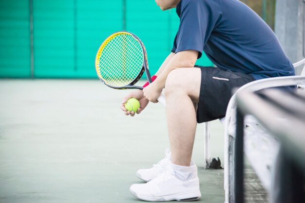 Triste joueuse de tennis assise sur le court après avoir perdu un match