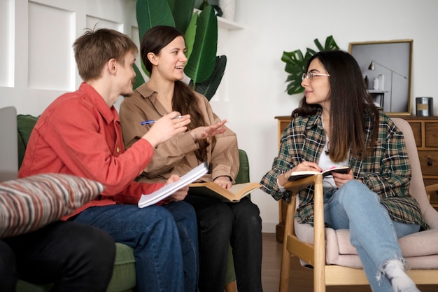 Trois amis apprennent à l'aide de leurs cahiers pendant la session d'étude