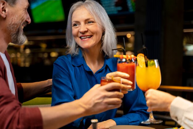 Trois amis seniors buvant dans un restaurant