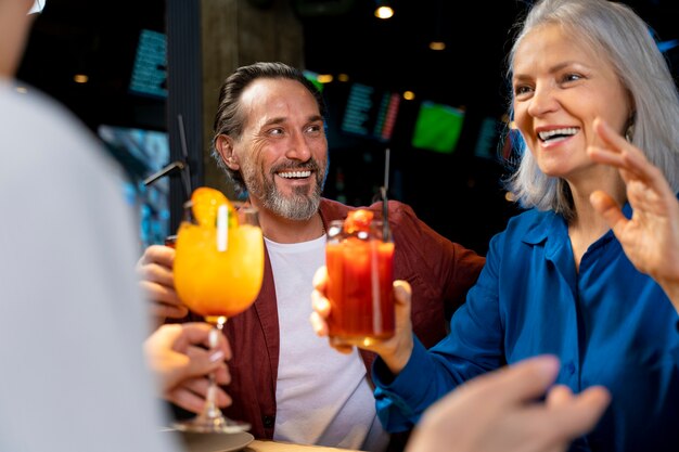 Trois amis seniors buvant et parlant dans un restaurant