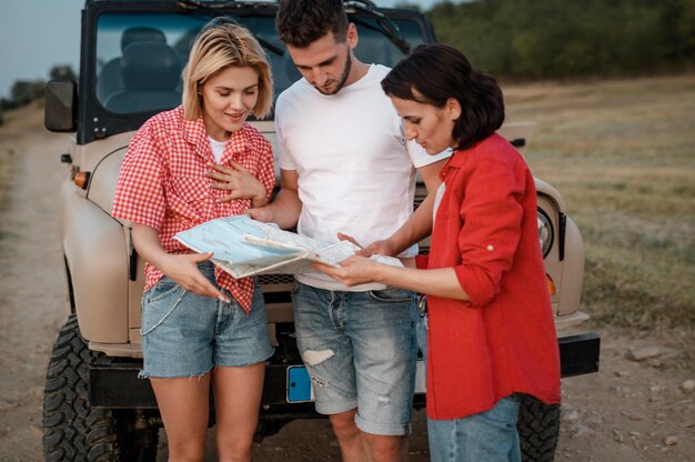 Trois amis vérifiant la carte lors d'un voyage en voiture