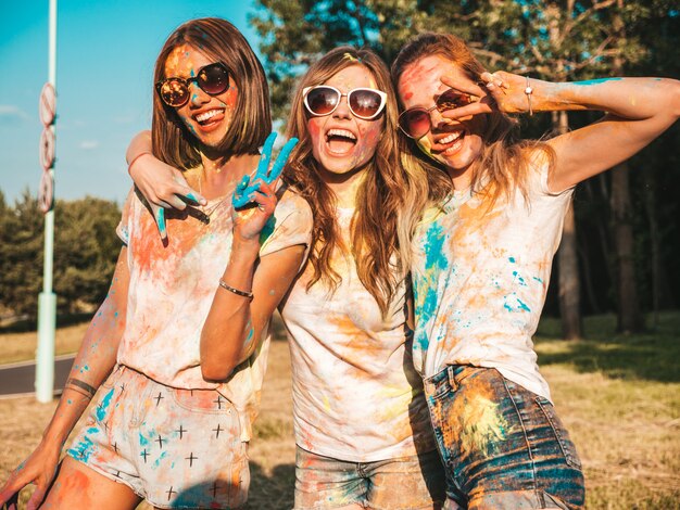 Trois belles filles souriantes posant à la fête de Holi