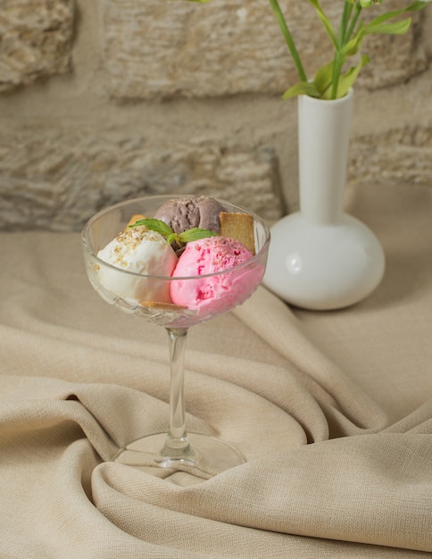 Photo gratuite trois boules de crème glacée au café, au vanille et à la fraise dans un verre de cristal
