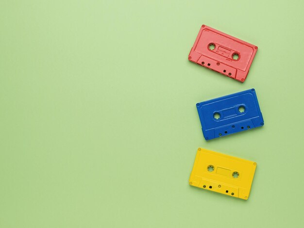 Trois cassettes de ruban multicolores sur fond vert clair. style vintage dans l'enregistrement sonore. mise à plat.