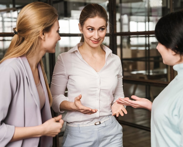 Trois femmes d'affaires discutant à l'intérieur