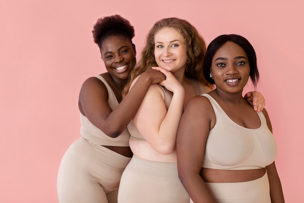 Trois femmes souriantes posant tout en portant un body shaper