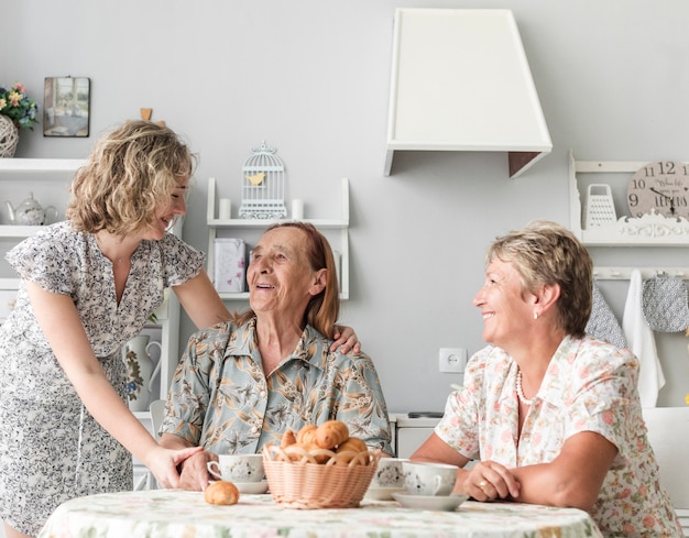 Trois générations de femmes prenant leur petit déjeuner en cuisine