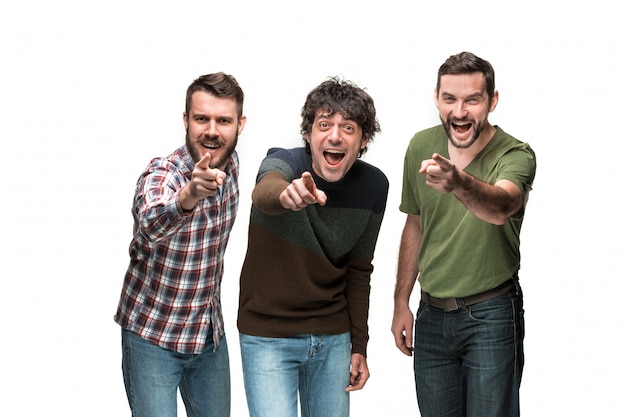 Photo gratuite les trois hommes sourient, regardent et pointent la caméra