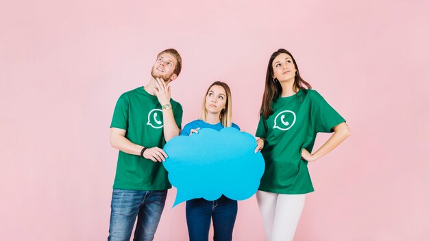 Trois jeunes amis contemplés tenant une bulle bleue