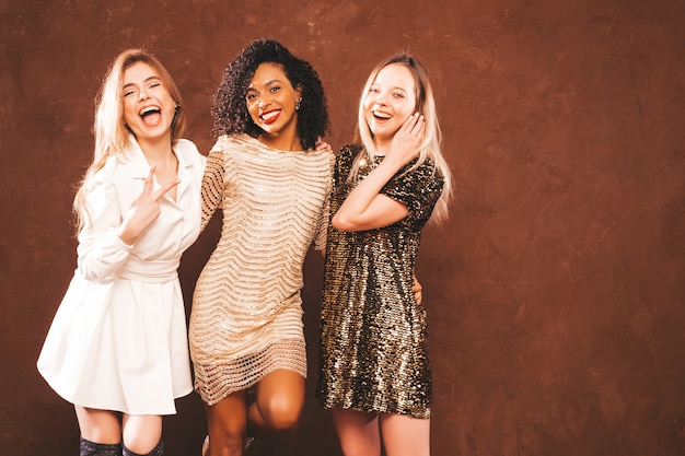 Photo gratuite trois jeunes belles femmes brunes internationales en robe brillante d'été à la mode.