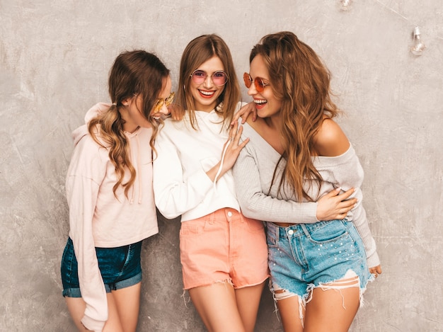 Trois Jeunes Belles Filles Souriantes Dans Des Vêtements De Sport D'été à La Mode. Femmes Insouciantes Sexy Posant. Modèles Positifs En Lunettes De Soleil Rondes S'amusant. étreindre