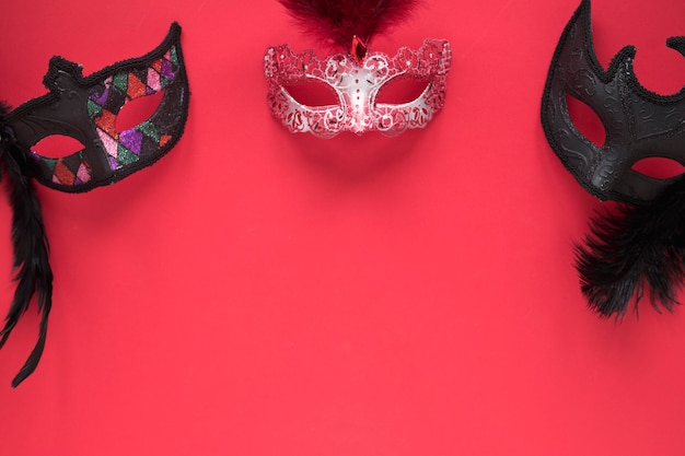 Photo gratuite trois masques sur le rouge