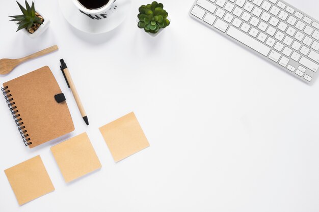 Trois notes vierges adhésives avec journal intime; stylo et clavier sur fond blanc