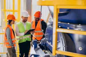 Photo gratuite trois personnes discutant d'un plan dans une usine