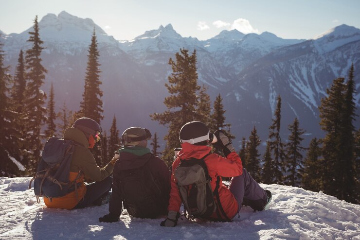 Photo gratuit trois skieurs se détendre sur la montagne couverte de neige