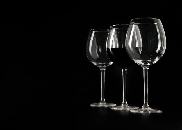 Trois verres à vin sur fond noir