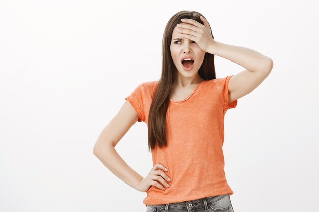 Troublée et inquiète jeune femme gifle le front et l'air frustré ou anxieux